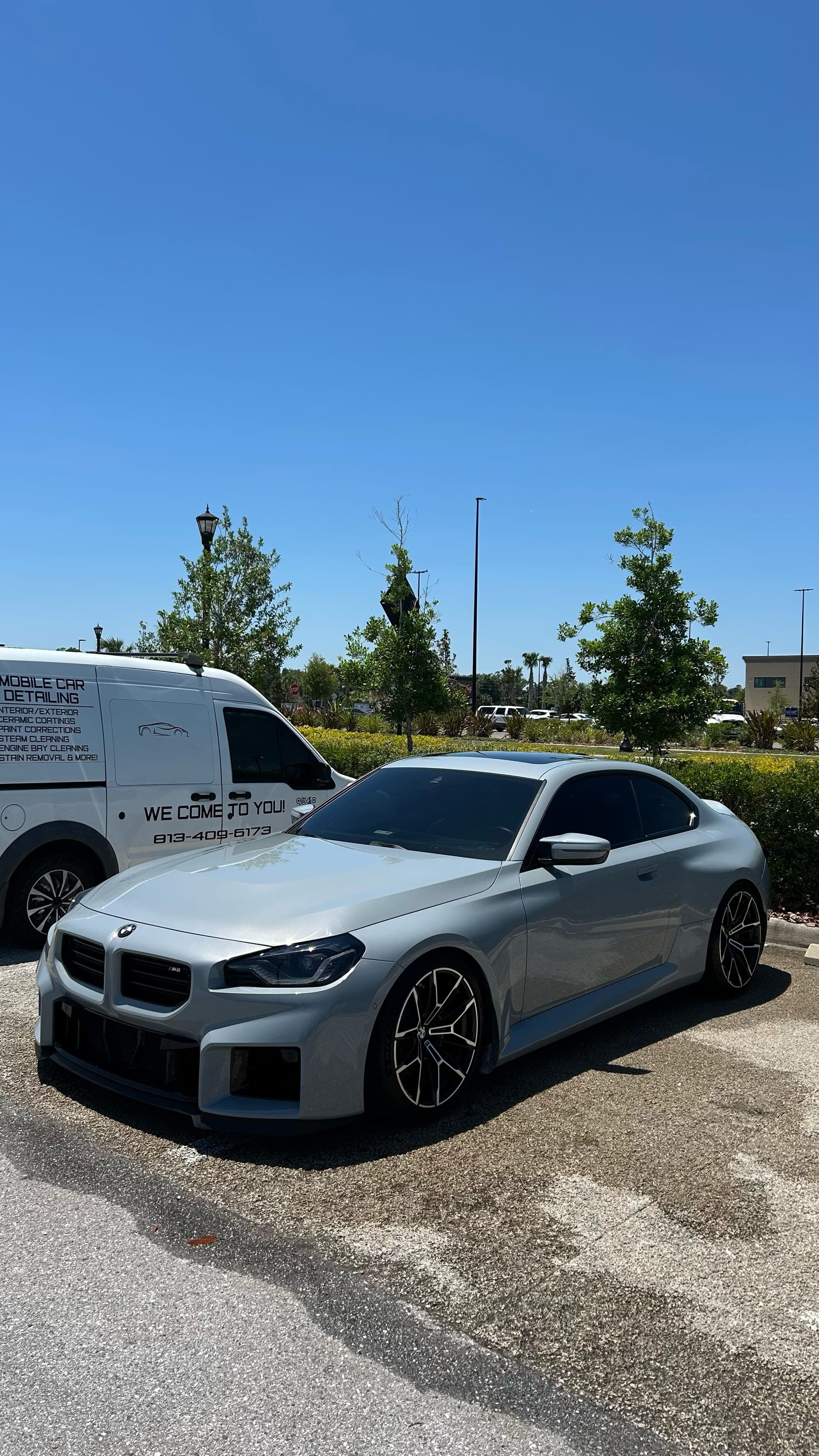 BMW M2 beside the Platinum Auto Care van, mobile detailing on site in Tampa